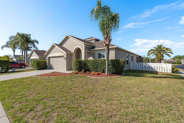 single story home with fence, an attached garage, a front lawn, stucco siding, and driveway