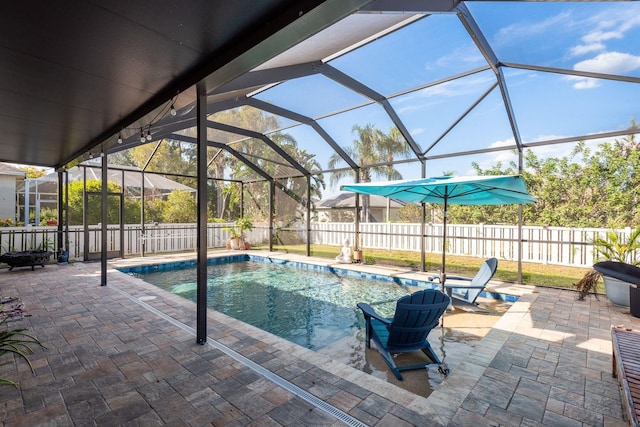 view of pool featuring a fenced in pool, a fenced backyard, glass enclosure, and a patio area