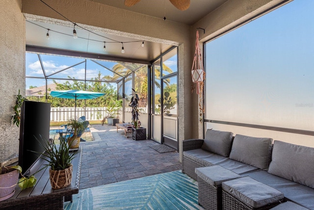 sunroom featuring ceiling fan and outdoor lounge area