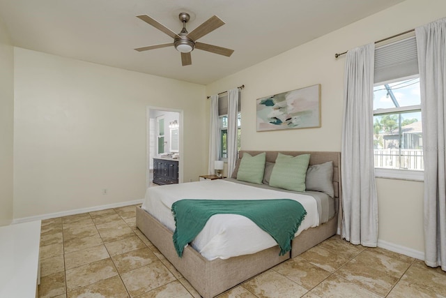 bedroom with baseboards, a ceiling fan, ensuite bathroom, and multiple windows