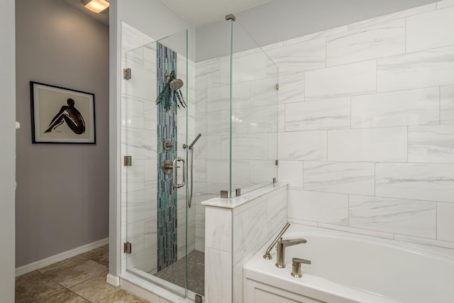 bathroom featuring baseboards, a bath, and a shower stall