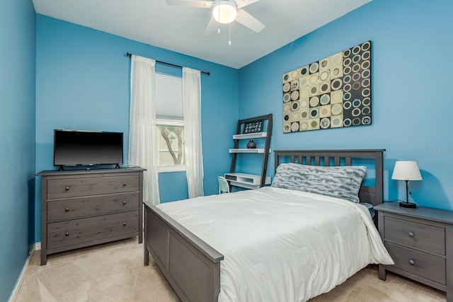 bedroom with ceiling fan, light colored carpet, and baseboards