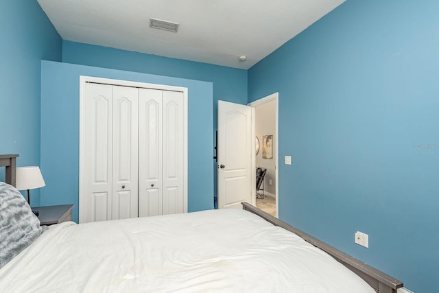 bedroom featuring baseboards, visible vents, and a closet