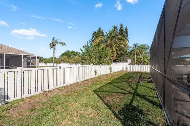 view of yard with a fenced backyard and a water view