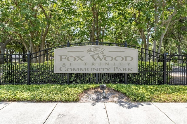 community / neighborhood sign with fence