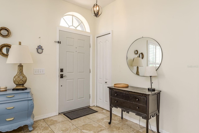 foyer entrance featuring light tile patterned floors and baseboards