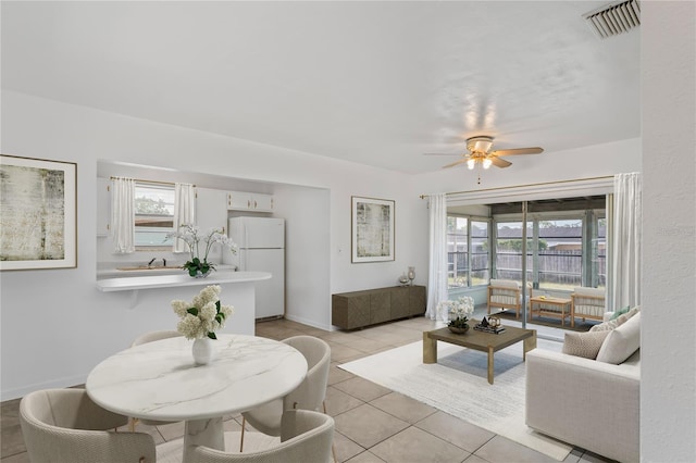 7050 Merrick Ln, Spring Hill, FL 34606 - living room with ceiling fan, plenty of natural light, and light tile patterned floors