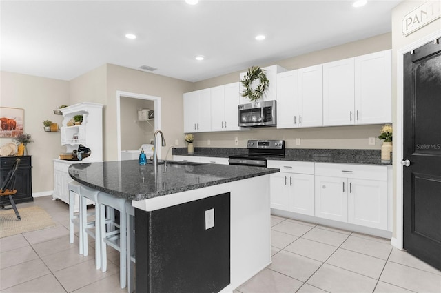 2132 Shining Azul Way, Lutz, FL 33558 - kitchen featuring stainless steel appliances, a sink, light tile patterned floors, an island with sink, and white cabinetry