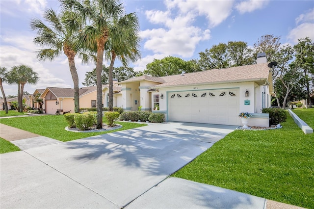 mediterranean / spanish home with a front lawn, a garage, stucco siding, a chimney, and driveway
