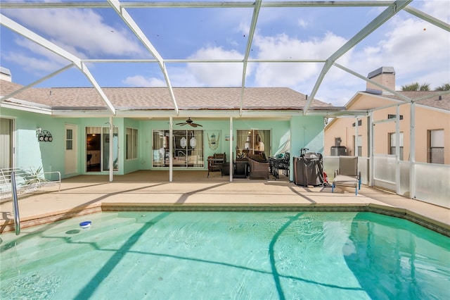 rear view of house featuring a ceiling fan, an outdoor pool, glass enclosure, a patio, and stucco siding