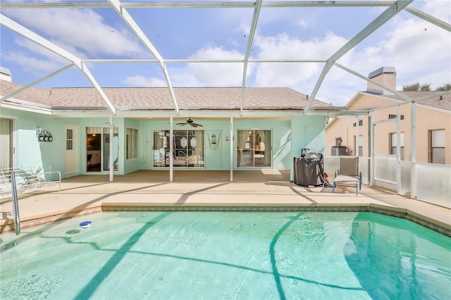 rear view of house featuring ceiling fan, a patio, an outdoor pool, stucco siding, and roof with shingles