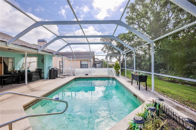 outdoor pool with glass enclosure and a patio area