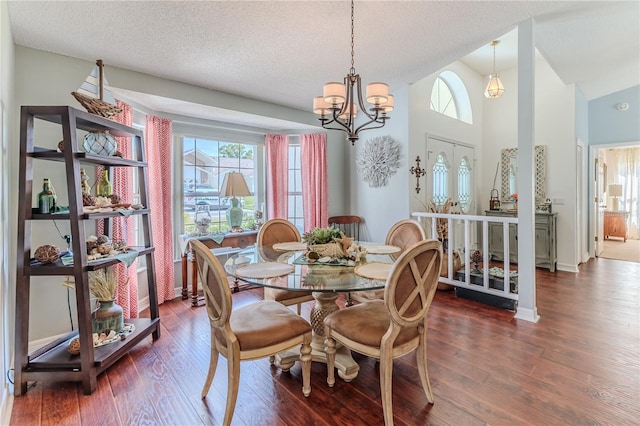 dining area with an inviting chandelier, a textured ceiling, wood finished floors, and a wealth of natural light