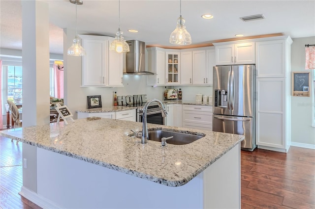 kitchen featuring a sink, wall chimney exhaust hood, stainless steel appliances, visible vents, and dark wood-style floors