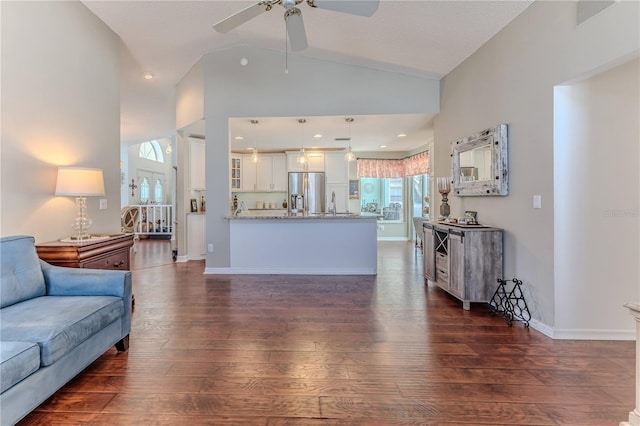 living area with a ceiling fan, baseboards, recessed lighting, lofted ceiling, and dark wood-style floors
