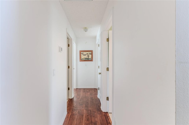 hallway featuring baseboards and wood finished floors