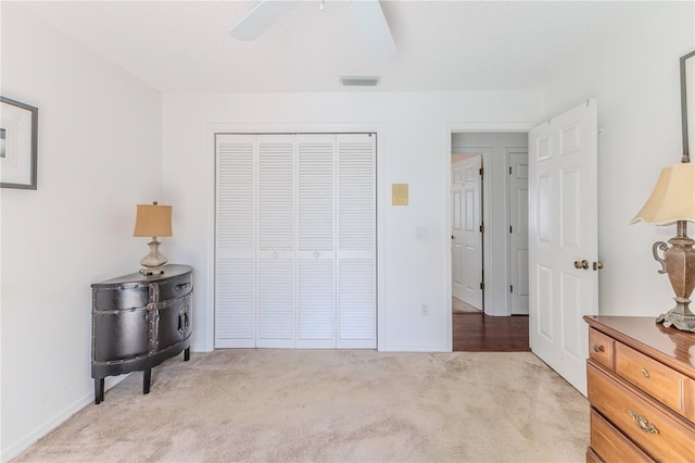 bedroom with a closet, baseboards, light colored carpet, and visible vents