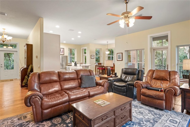 living area featuring recessed lighting, ceiling fan with notable chandelier, and wood finished floors