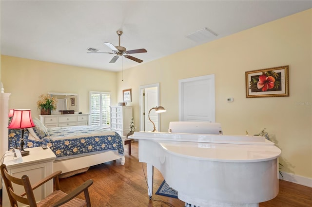 bedroom with visible vents, a ceiling fan, baseboards, and wood finished floors