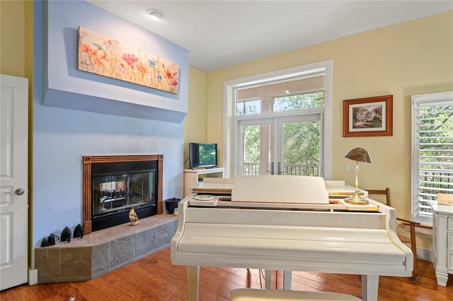sitting room featuring a tile fireplace and wood finished floors