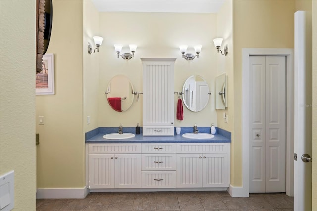 full bathroom featuring a sink, tile patterned flooring, and double vanity