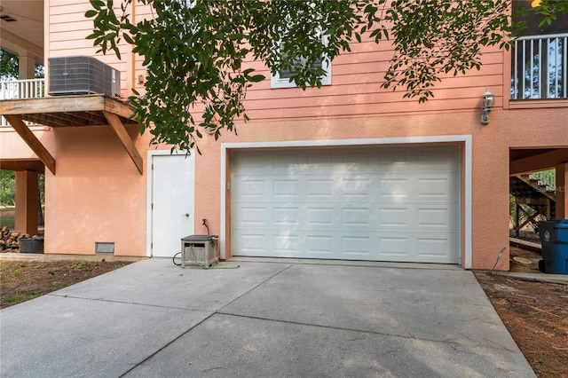 garage featuring concrete driveway and central AC unit