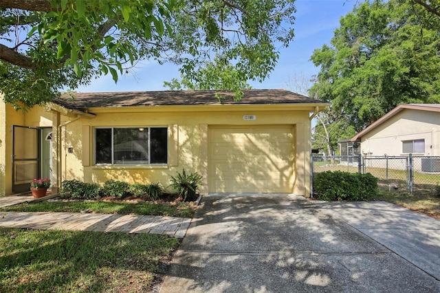 12906 Sandburst Ln, Hudson, FL 34667 - ranch-style house with fence, an attached garage, stucco siding, central AC unit, and driveway