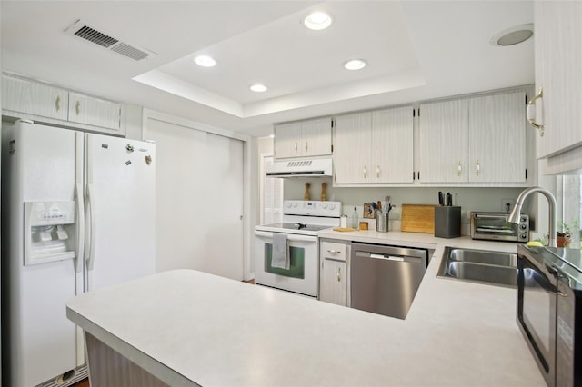 12906 Sandburst Ln, Hudson, FL 34667 - kitchen featuring visible vents, white appliances, range hood, light countertops, and a tray ceiling