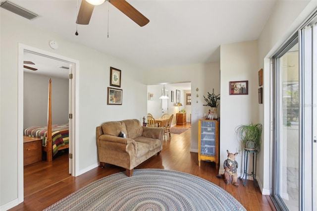 12906 Sandburst Ln, Hudson, FL 34667 - living room featuring a ceiling fan, baseboards, visible vents, and wood finished floors
