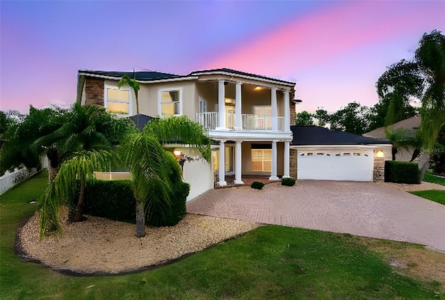 15906 Prince William Pl, Odessa, FL 33556 - view of front facade with a balcony, driveway, a garage, covered porch, and stone siding