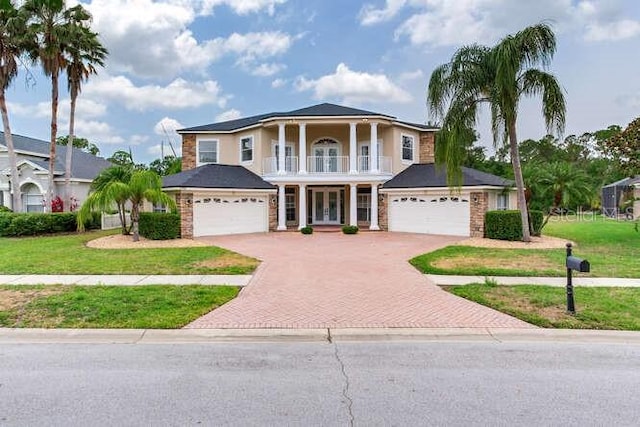 15906 Prince William Pl, Odessa, FL 33556 - greek revival house with french doors, a balcony, decorative driveway, and a front lawn
