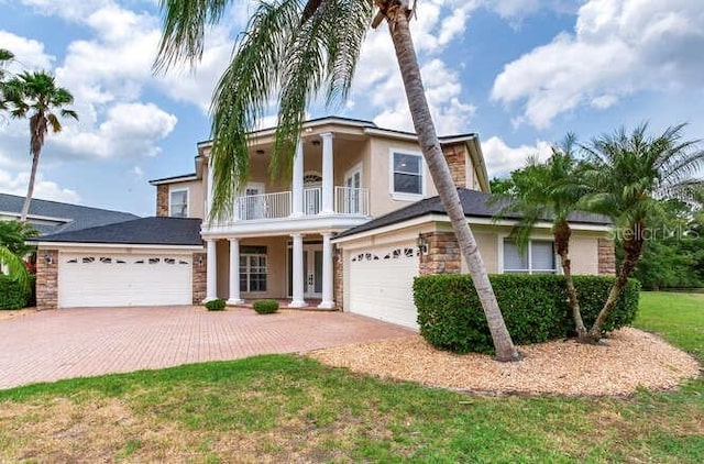 15906 Prince William Pl, Odessa, FL 33556 - view of front of property with a balcony, driveway, stucco siding, stone siding, and an attached garage
