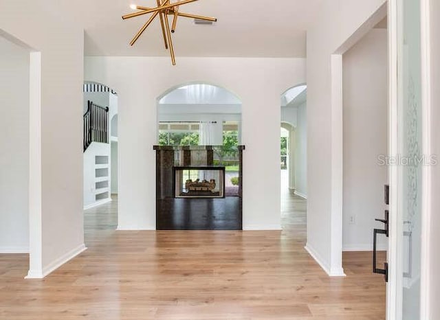 15906 Prince William Pl, Odessa, FL 33556 - foyer featuring light wood finished floors, a multi sided fireplace, and arched walkways