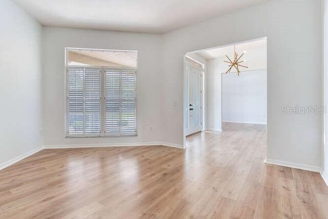 15906 Prince William Pl, Odessa, FL 33556 - unfurnished room featuring a chandelier, light wood-type flooring, and baseboards