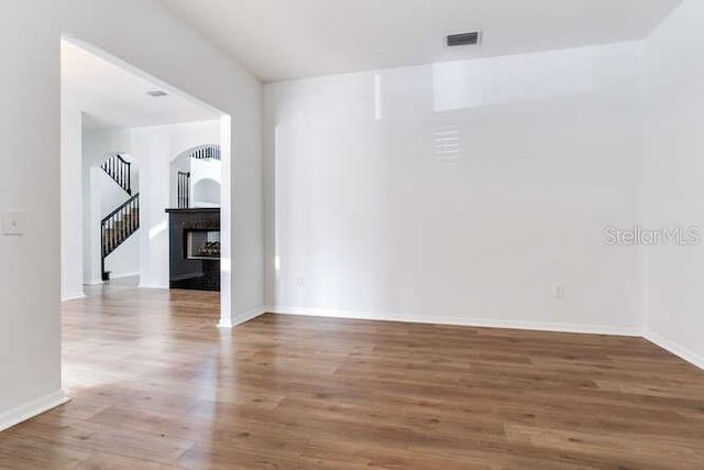 15906 Prince William Pl, Odessa, FL 33556 - unfurnished room featuring wood finished floors, baseboards, stairs, and a fireplace
