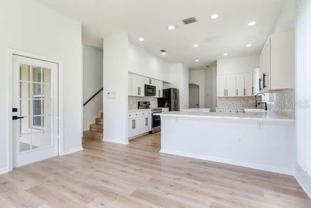 15906 Prince William Pl, Odessa, FL 33556 - kitchen with stainless steel range with electric cooktop, black microwave, a sink, tasteful backsplash, and freestanding refrigerator