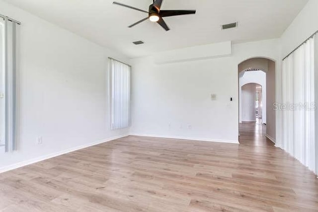 15906 Prince William Pl, Odessa, FL 33556 - spare room featuring arched walkways, wood finished floors, ceiling fan, and baseboards