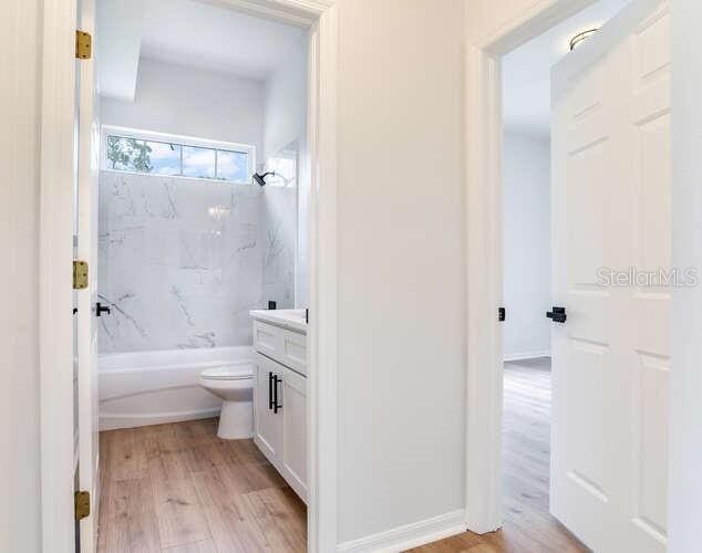 15906 Prince William Pl, Odessa, FL 33556 - bathroom featuring vanity, wood finished floors, toilet, and  shower combination