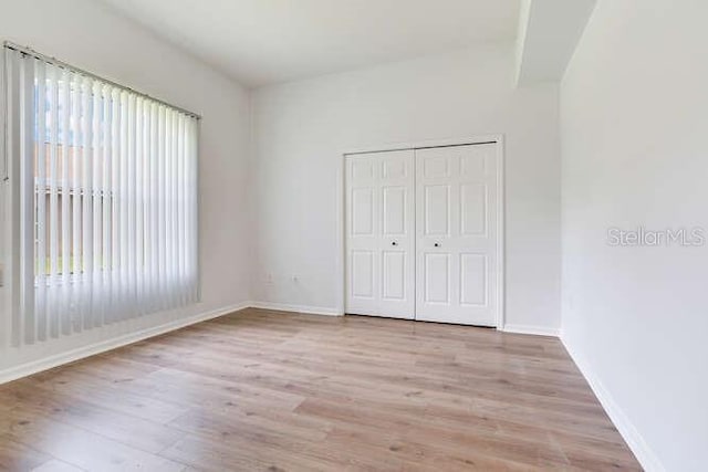 15906 Prince William Pl, Odessa, FL 33556 - unfurnished bedroom with wood finished floors, baseboards, and a closet