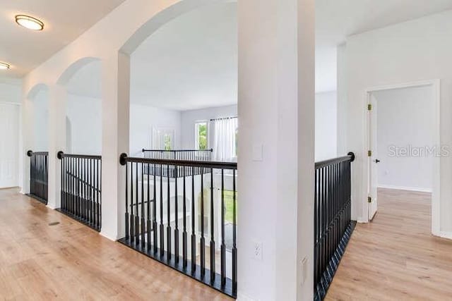 15906 Prince William Pl, Odessa, FL 33556 - hall with wood finished floors, arched walkways, and an upstairs landing