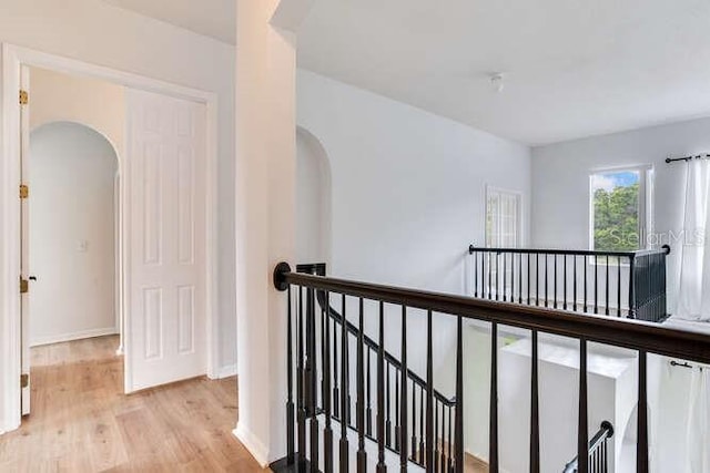 15906 Prince William Pl, Odessa, FL 33556 - corridor with an upstairs landing, arched walkways, light wood-style floors, and baseboards