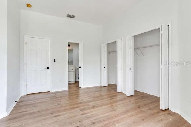 15906 Prince William Pl, Odessa, FL 33556 - unfurnished bedroom with two closets, light wood-style flooring, and baseboards