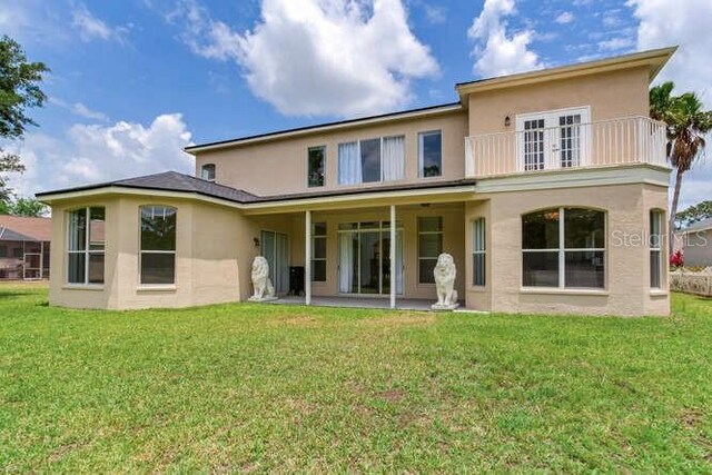 15906 Prince William Pl, Odessa, FL 33556 - rear view of property with stucco siding, a balcony, and a yard