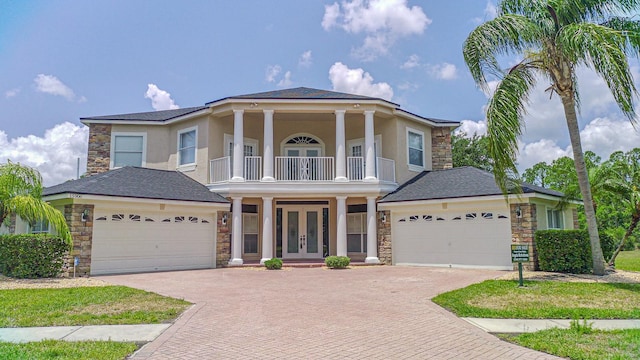 15906 Prince William Pl, Odessa, FL 33556 - neoclassical / greek revival house with french doors, stone siding, a balcony, and a garage