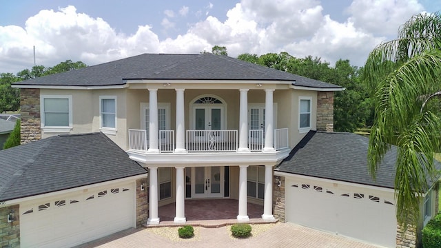15906 Prince William Pl, Odessa, FL 33556 - greek revival inspired property with french doors, a garage, and stone siding
