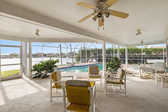 sunroom / solarium with a ceiling fan, a water view, and healthy amount of natural light