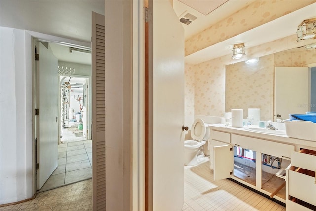 bathroom with wallpapered walls, vanity, tile patterned flooring, and toilet