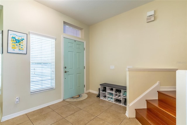 foyer with light tile patterned floors, plenty of natural light, and baseboards