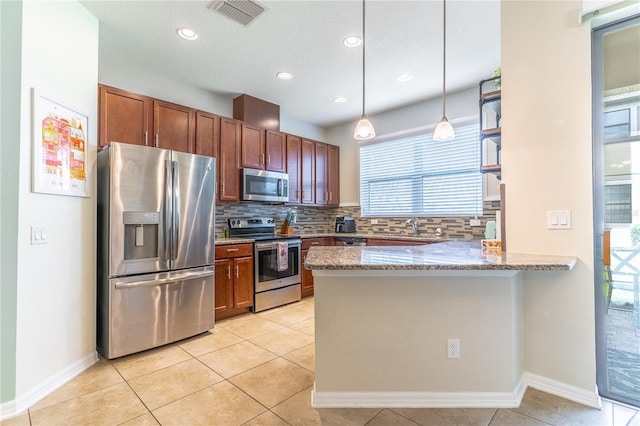 kitchen featuring stainless steel appliances, a peninsula, backsplash, light stone counters, and pendant lighting