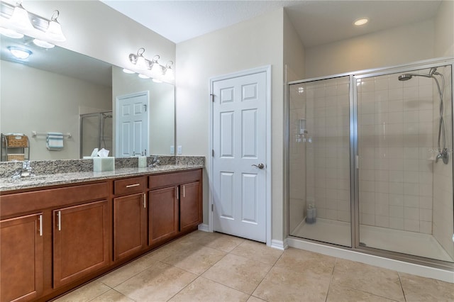 full bath featuring a shower stall, tile patterned flooring, and double vanity